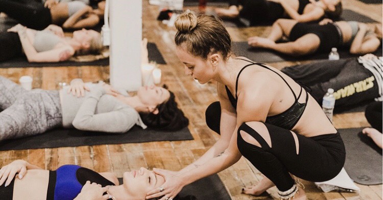 Anja working as a yoga teacher leading a yoga class for clients