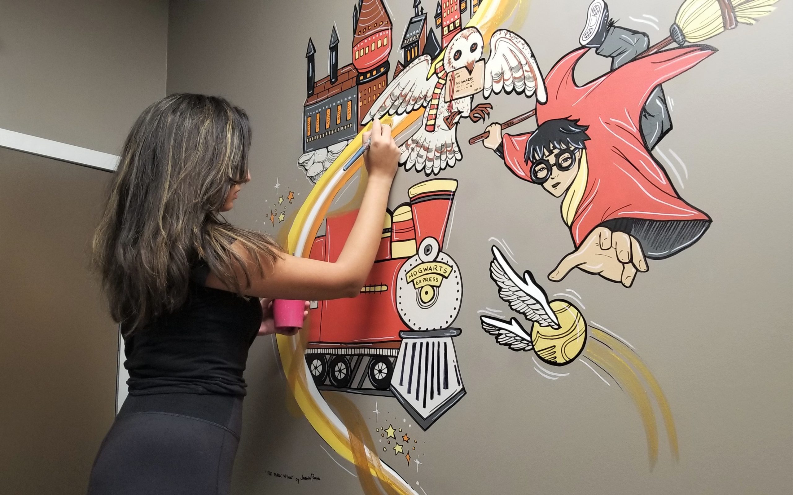 GTA artist Jasmin Pannu painting a commissioned wall art piece for a child’s room