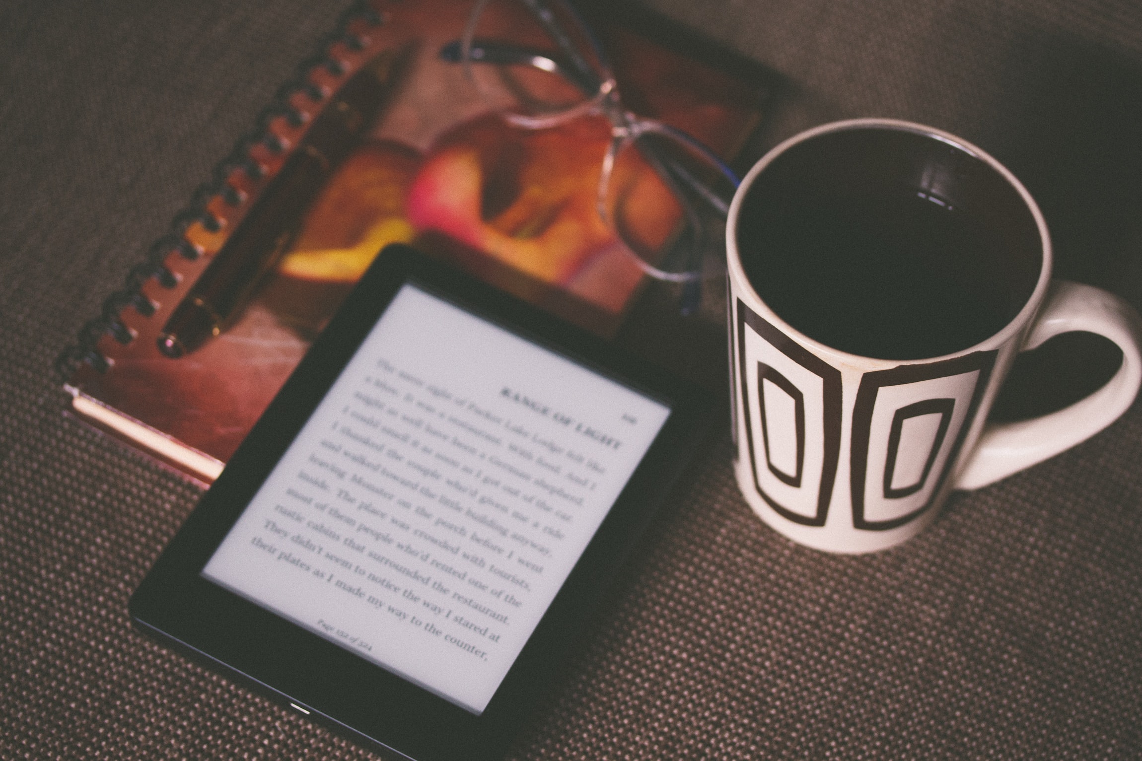 Ebook publishing platform open on a table beside a mug of coffee