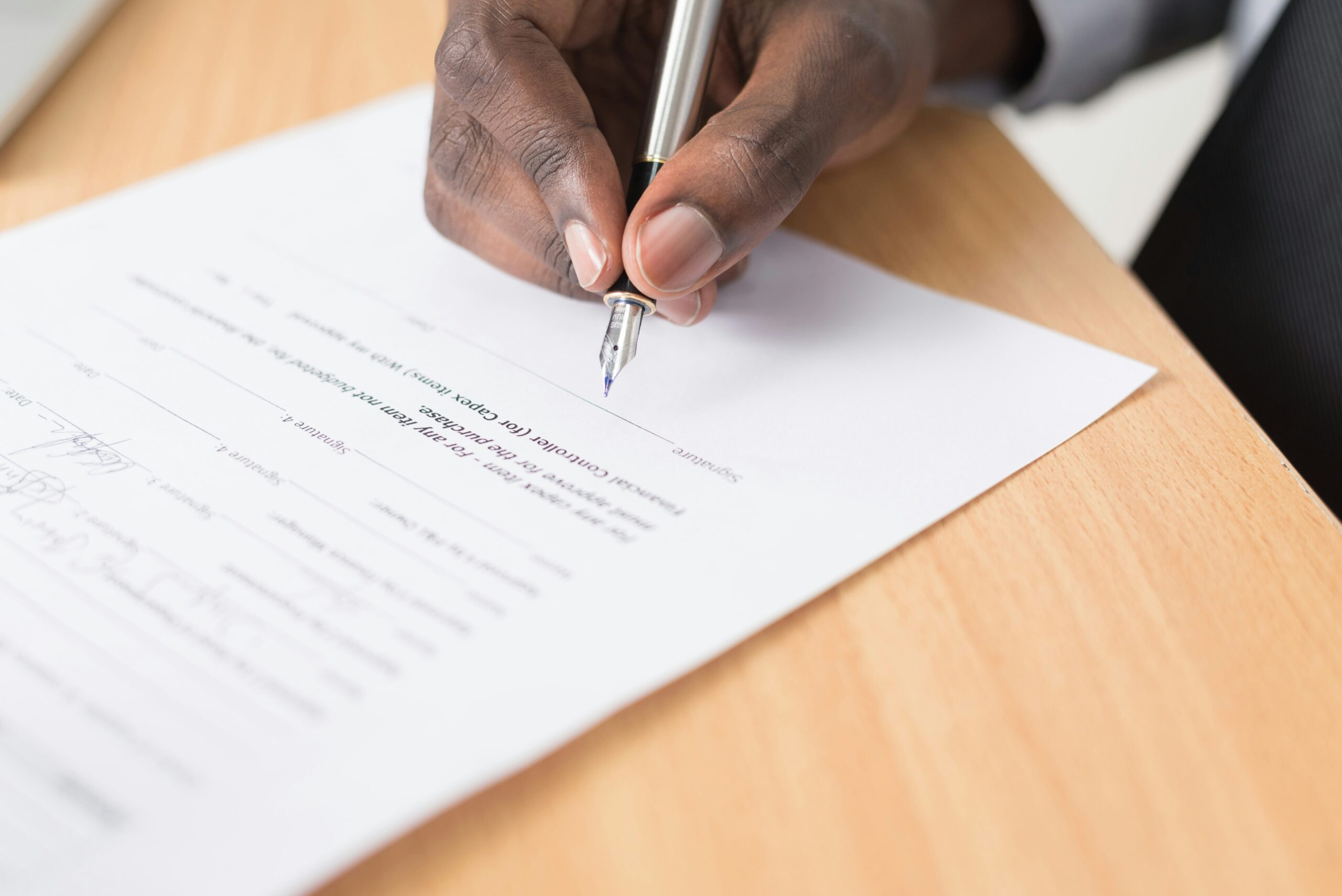 Close-up of a business professional's hands pointing at a detailed checklist and compliance matrix during an RFP review.