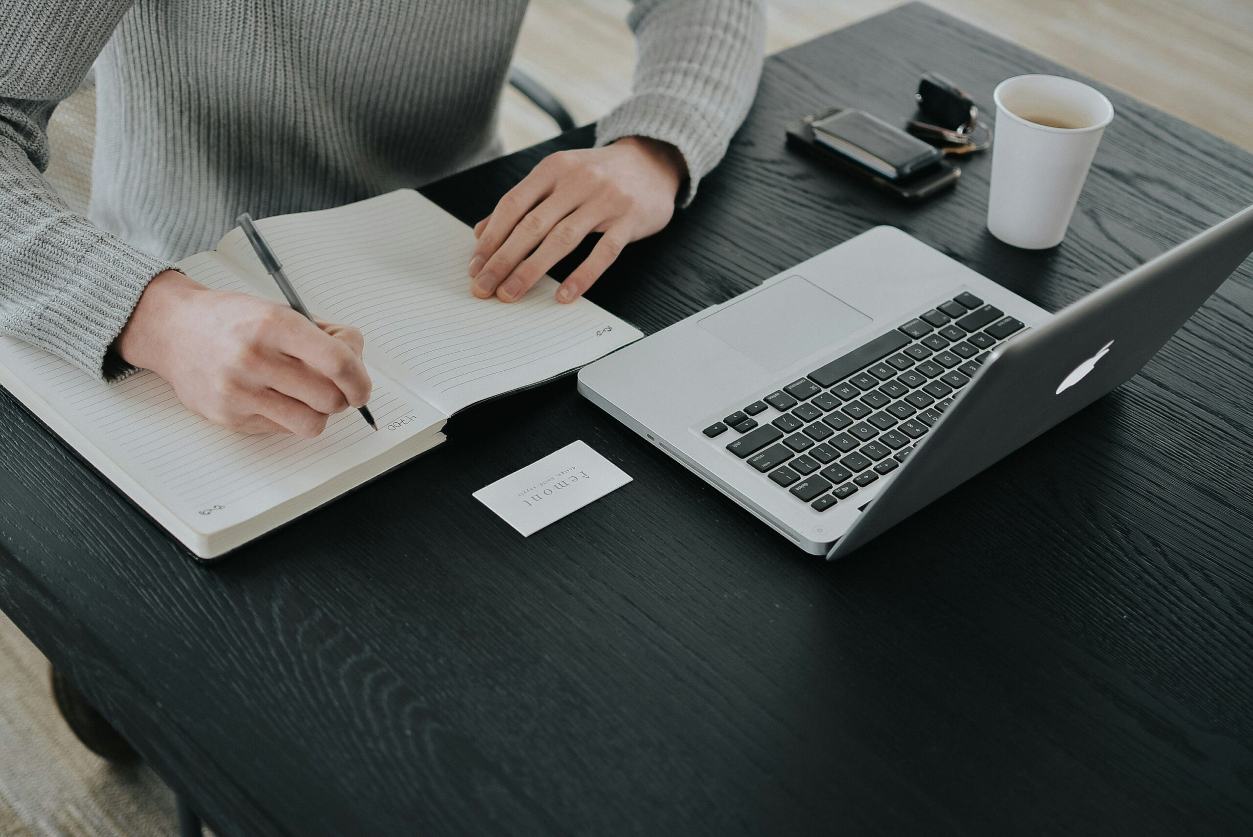 Grant writer drafting a funding proposal at a desk with notes and a laptop, illustrating what grant writing is
